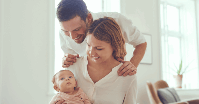Father comforting mother holding newborn, representing support and teamwork in managing baby blues