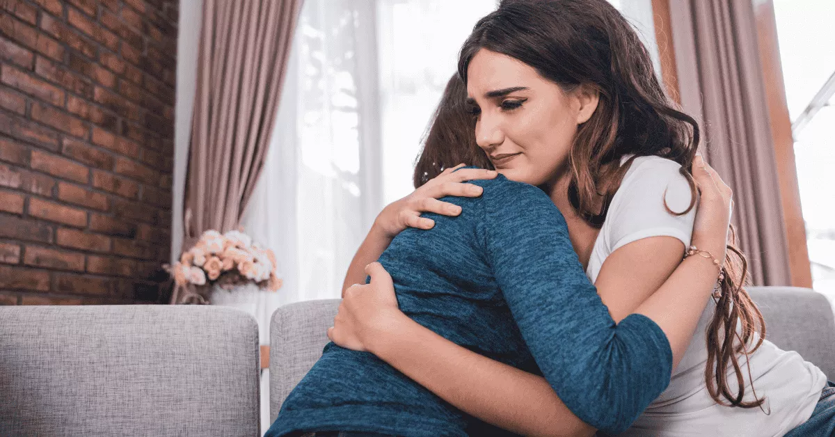 Two women embracing and offering emotional comfort to each other while coping with the challenges of fertility treatments.