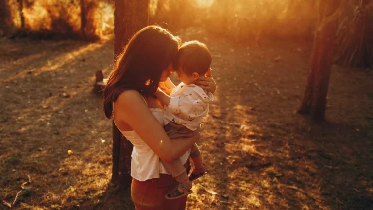 Mother holding her newborn, illustrating the success of postpartum therapy techniques to overcome mom guilt.