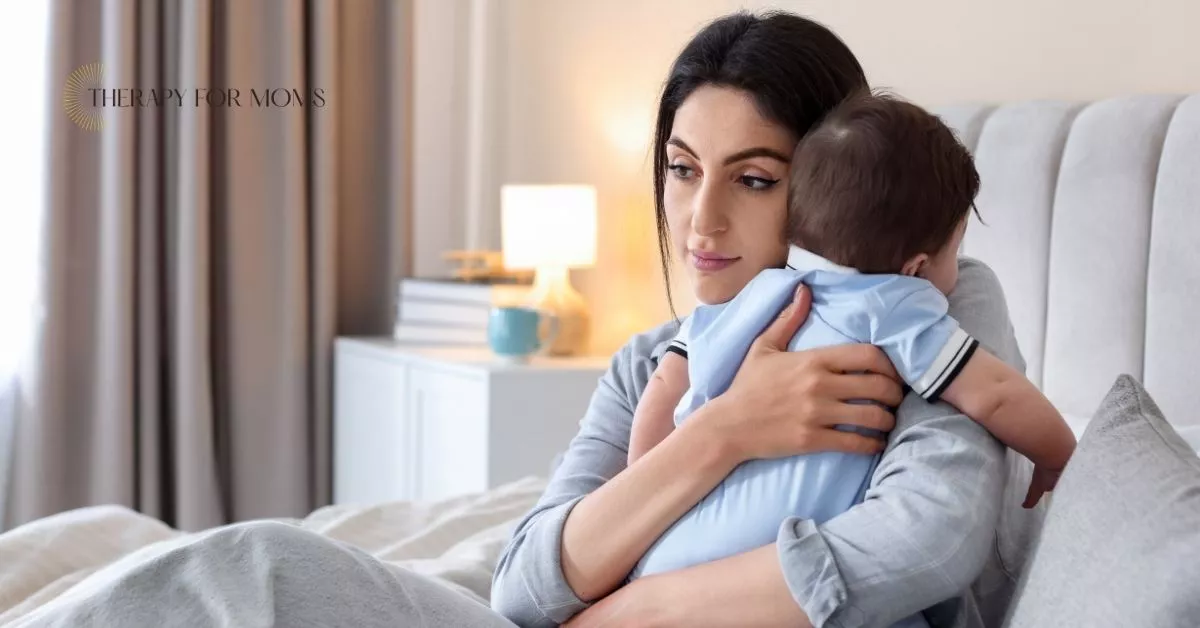 Exhausted mother holding baby in bedroom, reflecting emotional overwhelm and postpartum struggles