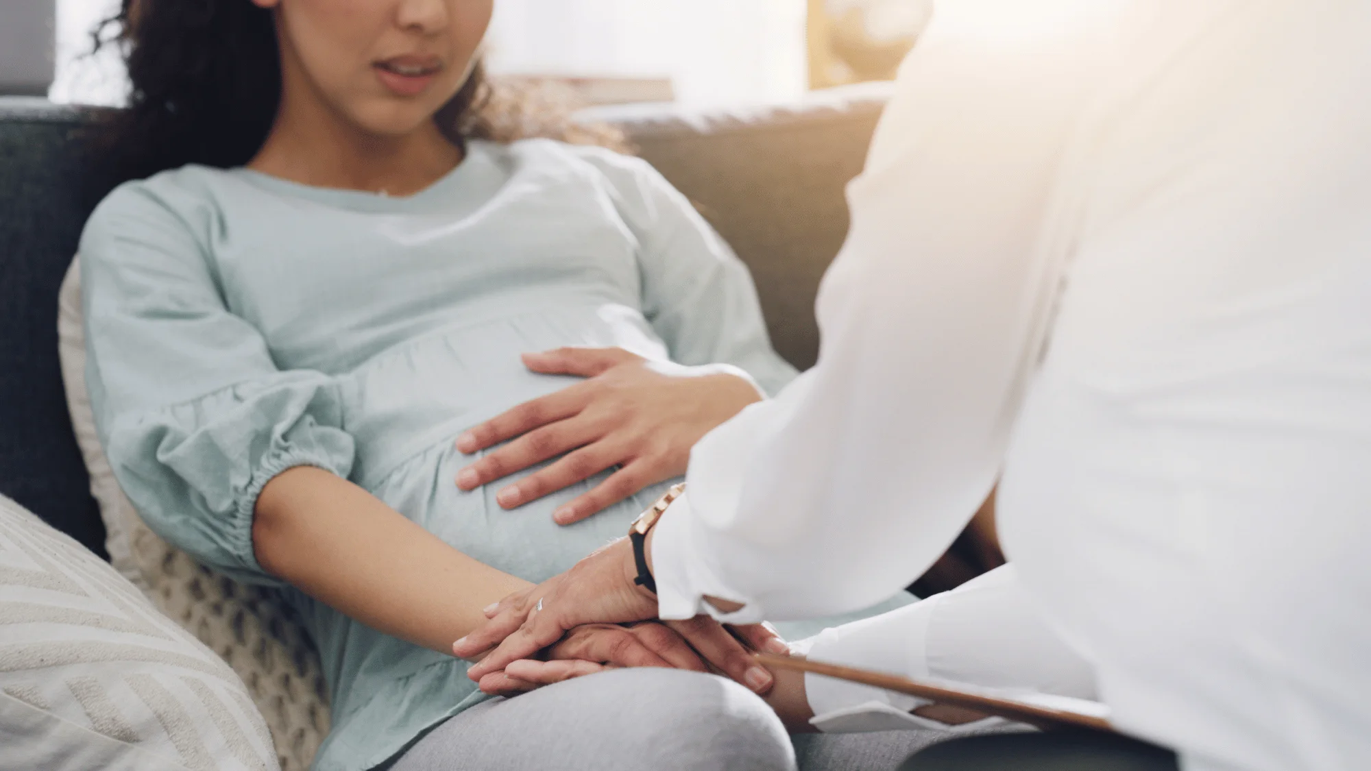 Pregnant woman receiving compassionate support from a therapist during a perinatal counseling session, representing the process of finding specialized mental health care for pregnancy and postpartum challenges in Houston.