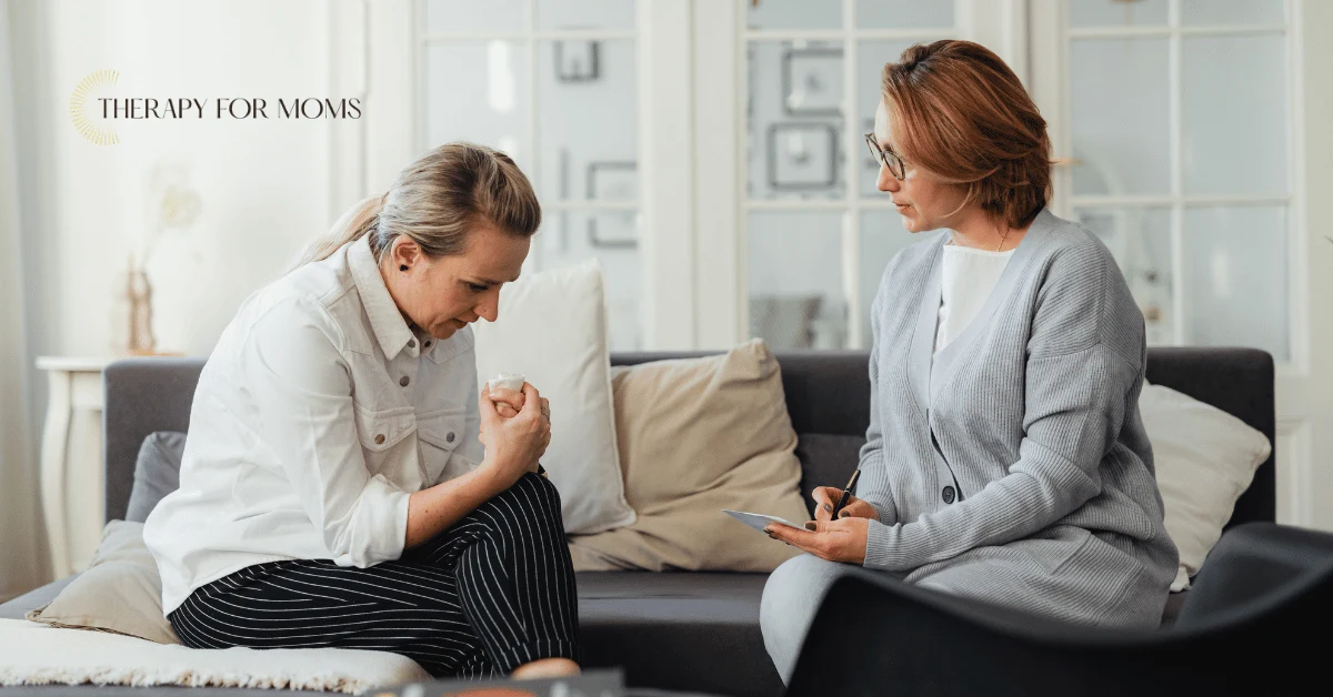 Woman meeting with a perinatal therapist in a comfortable counseling setting, demonstrating personalized support for navigating pregnancy, postpartum recovery, and motherhood-related mental health concerns.